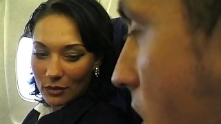 Brunette beauty wearing stewardess uniform gets fucked on a plane